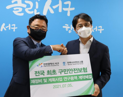 왼쪽부터 오세문 위맥사이먼리그룹 회장과 오른쪽 이재현 인천 서구청장이 업무협약식에서 기념 촬영을 하고 있다