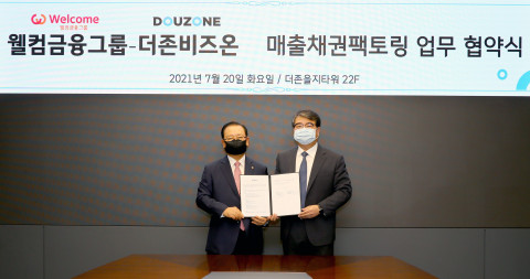 왼쪽부터 손종주 웰컴금융그룹 회장과 김용우 더존비즈온 대표가 업무협약을 맺고 기념촬영을 하고 있다