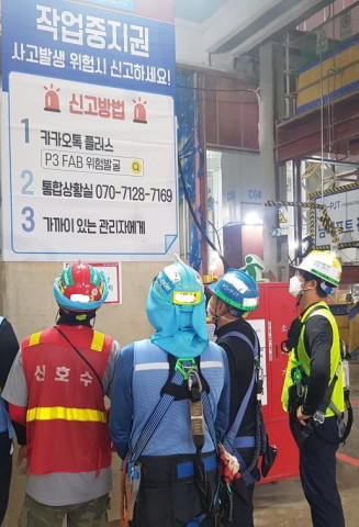 근로자들이 근로자 작업 중지권에 대한 안내문을 보고 있다