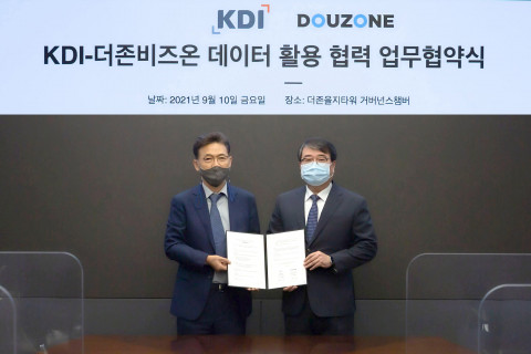 왼쪽부터 홍장표 한국개발연구원장과 김용우 더존비즈온 김용우 대표가 업무 협약을 맺고 기념촬영을 하고 있다