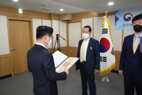 박범계 법무부 장관이 출소자의 재범 방지를 위해 힘써온 윤용병 법무보호위원에게 정부 포상 목련장을 수여하고 있다