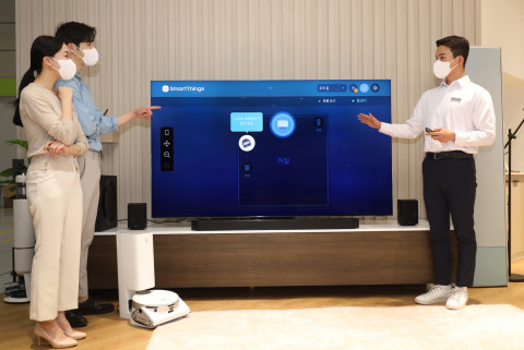 월드 IT쇼 2022 삼성전자관에 마련된 팀삼성 홈의 IoT 리빙룸에서 관람객이 IoT 허브가 탑재된 ‘Neo QLED 8K’로 별도 허브 없이도 스마트싱스를 이용해 다양한 가전과