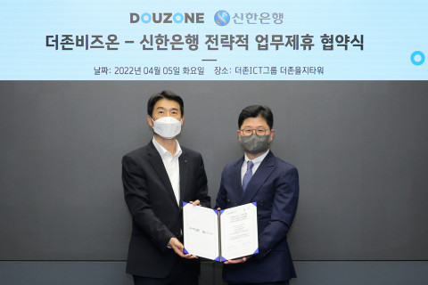 왼쪽부터 최익성 신한은행 부행장과 더존비즈온 지용구 솔루션사업부문 대표가 업무 협약서를 교환하고 있다