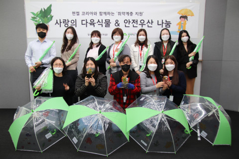 헨켈코리아 임직원들이 안전우산과 다육식물을 제작 후 기념 촬영을 하고 있다