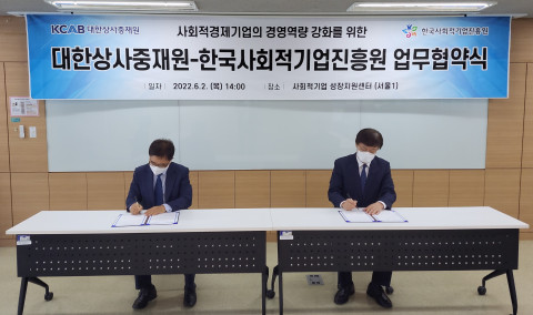 왼쪽부터 한국사회적기업진흥원 정현곤 원장, 대한상사중재원 맹수석 원장이 업무 협약서에 서명을 하고 있다