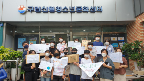 환경 보호를 위한 거리 캠페인에 참여한 청소년들이 기념 촬영을 하고 있다