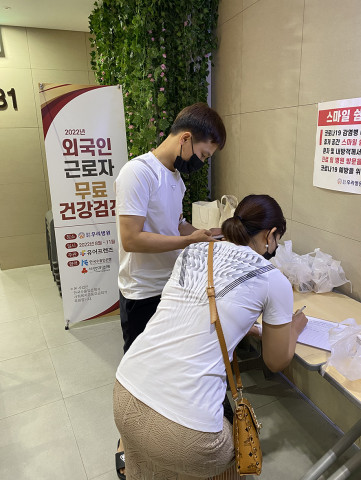 건강검진을 마친 외국인 근로자가 종합 비타민을 수령하고 있다