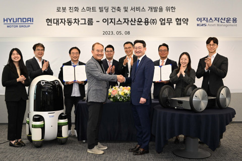 현대차∙기아의 실내외 배송 로봇(왼쪽)과 모베드(MobED, 오른쪽)가 놓인 가운데 현대차·기아 연구개발본부장 김용화 부사장(앞줄 왼쪽)과 이지스자산운용 리얼에셋부문 정석우 대표(