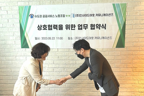 수도권공공서비스 노동조합 박영란 위원장과 인사이드아웃 커뮤니케이션즈 김상현 대표가 협약서 교환 후 악수를 하고 있다