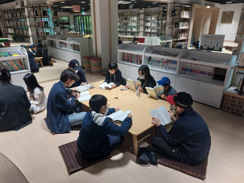 청소년들이 둘러 앉아 낭독 책읽기를 하고 있다