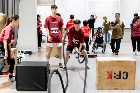 남성 참여자가 경기 동작(배틀로프)를 수행하고 있다. 뒤로는 휠체어를 탄 아이가 보인다