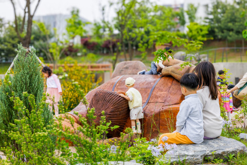 KAC열린놀이공간 ‘거인의 정원’에 있는 거인 조형물에서 노는 아이들 모습