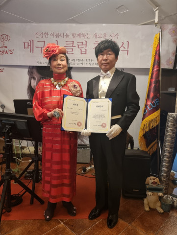 이토메구미 캐릭터메구스 회장이 메구미클럽 초대회장으로 추대된 한용찬 네로 대표에게 추대장을 수여하고 있다