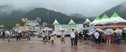 갑자기 내린 비로 우산을 준비하지 못한 관광객들이 현수막 우산을 쓰고 한탄강 가든페스타를 즐기고 있다