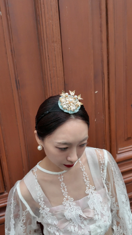 한복 헤어 장식 디테일 클로즈업. 금장 장식과 진주가 어우러진 전통미로 전체 스타일에 깊이를 더했다