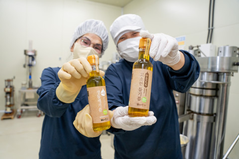 농업회사법인 내포의 직원들이 친환경 토종 들깨를 활용한 들기름 제품을 들고 밝게 웃고 있다