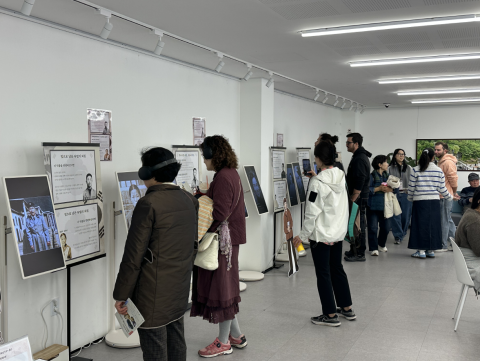 지역주민들이 청소년들이 제작한 AI 아트워크 전시를 관람하고 있다