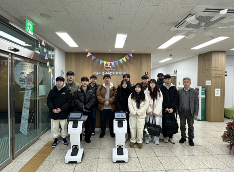 한국공학대학교 지능형로봇 혁신융합대학사업단이 시흥시 장곡종합사회복지관에서 모바일로봇을 활용한 지역사회 문제 해결 발표회를 개최했다. 발표회 참석자들이 모바일로봇 ‘Temi’와 함께