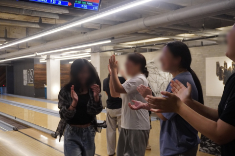 유스톡 스쿨 방학 모델 참여 청소년들이 볼링 활동 중 스트라이크를 친 친구를 박수로 축하하며 서로 격려하고 있다