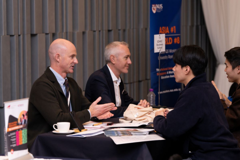 QS 박람회에서 행사 참가자가 학교 담당자와 대화를 나누고 있다