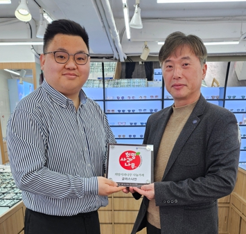 춘천 글라스나인 박경찬 대표(오른쪽)가 한국청소년연맹 ‘희망사과나무’ 나눔가게 현판을 전달받고 기념 촬영을 하고 있다