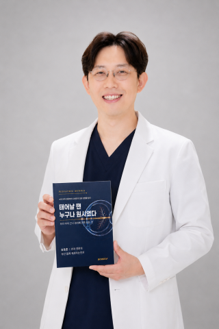 송동훈 애프터눈안과 대표원장이 직접 집필한 근시 관리 도서 ‘태어날 땐 누구나 원시였다’를 들고 미소 짓고 있다