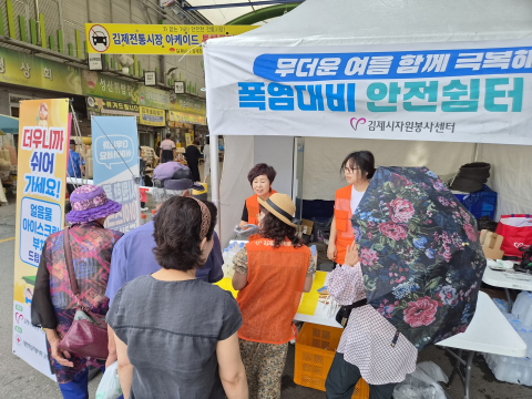 전북 김제시자원봉사센터에서 폭염 대비 ‘안전쉼터’를 설치하고, 김제전통시장 이용객과 상인들을 대상으로 생수, 부채 등 폭염 대비 물품을 나눠주고 있다