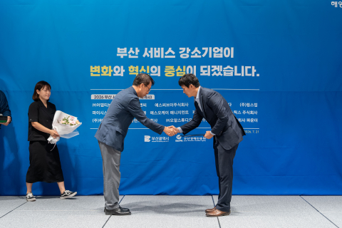 에스씨브이 이병관 공동대표가 ‘2026 부산 서비스 강소기업’ 인증서를 받고 축하 인사를 받고 있다(제공=부산광역시)