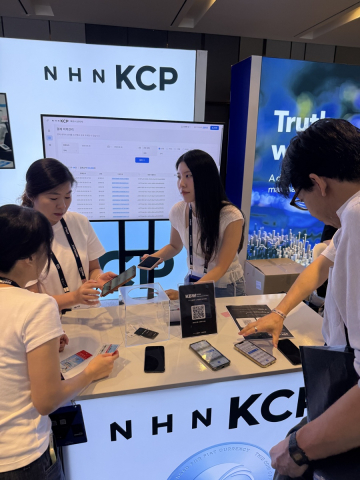 9월 30일 서울 워커힐 호텔앤리조트에서 열린 ‘KBW2026’ NHN KCP 부스에서 참관객이 원화 스테이블코인 결제 시연을 체험하고 있다