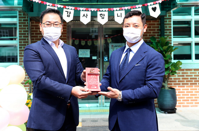 왼쪽부터 사랑의달팽이 조영운 사무국장이 AG코퍼레이션 김병건 대표에게 장근석&크리제이 ‘소울-The Fan 2호’ 인증패를 전달하고 있다.
