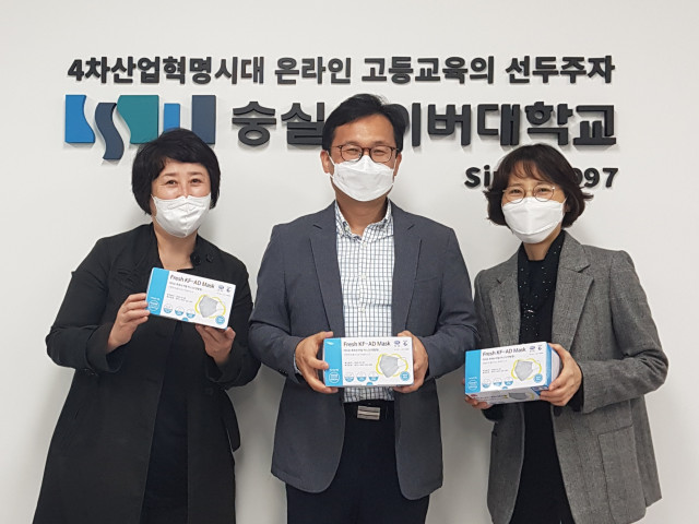 숭실사이버대학교 평생교육상담학과로부터 한국지역아동센터연합회 옥경원 대표(왼쪽부터 두 번째)가 마스크를 전달받고 있다