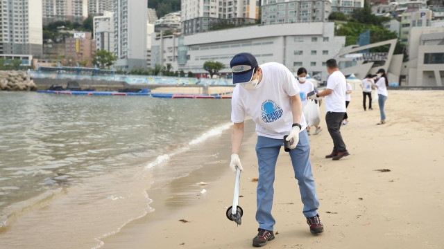 국제 해안 클린업 데이 행사에 참가한 동원산업 직원이 부산 송도해수욕장에서 쓰레기를 수거하고 있다