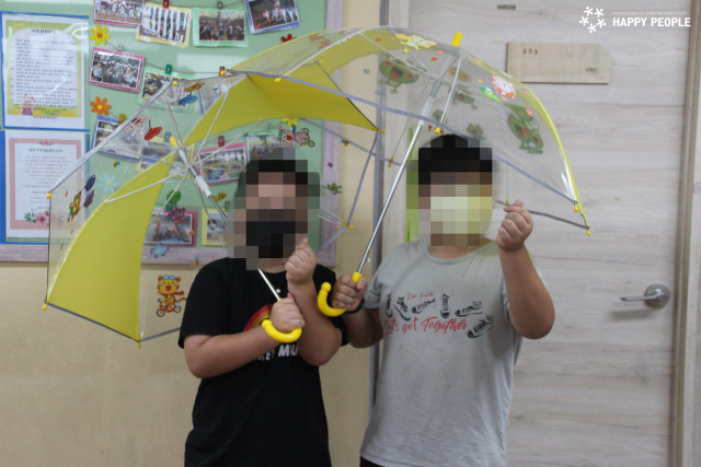 해피피플과 현대오토에버가 전달한 안전우산을 받은 아이들