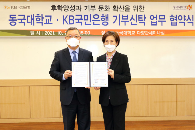 왼쪽부터 곽채기 동국대학교 교무부총장과 김종란 KB국민은행 금융투자상품 본부장이 협약식에서 기념 촬영을 하고 있다
