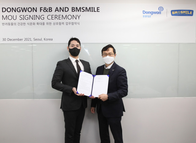 왼쪽부터 모성현 비엠스마일 한국 대표와 이상진 동원F&B 전략사업부장이 업무 협약을 맺고 기념촬영을 하고 있다