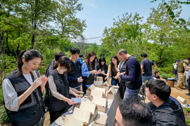 세계 벌의 날을 맞아 포르쉐 임직원들이 꿀벌정원에서 비호텔을 만들고 있다