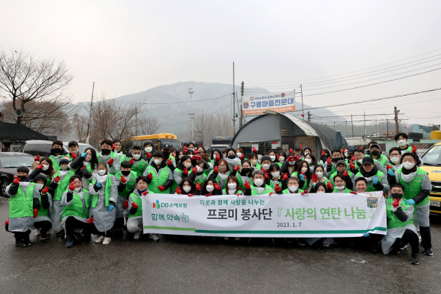 서울시 강남구 구룡마을 일대에서 DB손해보험 임직원과 가족들이 사랑의 연탄나눔 봉사활동을 진행하고 기념 촬영을 하고 있다