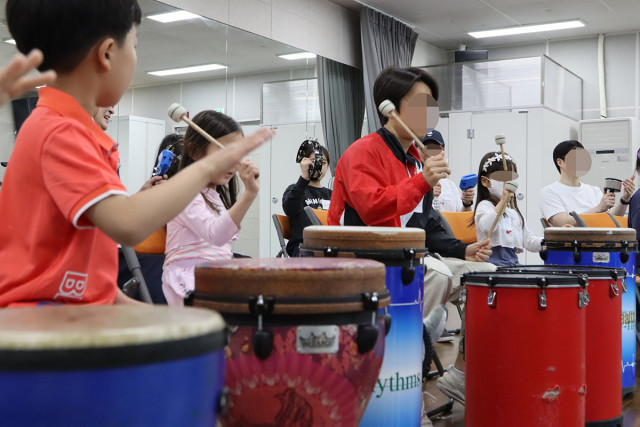 프로그램에 참석한 부모와 자녀가 타악기를 활용해 조화로운 음악을 만들어내고 있다