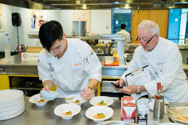 Judge/Chef Roland Passot (right) evaluates contestant Marcus Youn during the chef competition of You...