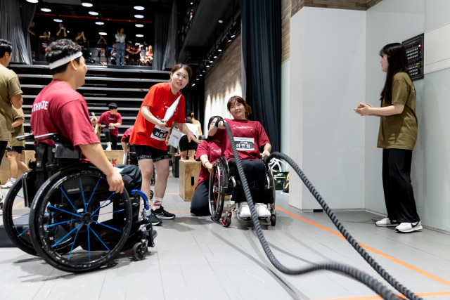 휠체어를 탄 여성 참여자가 경기 동작(배틀로프)을 수행하고 있다