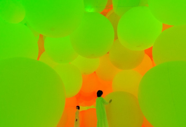 As visitors push the spheres of light, the spheres change color and emit a color-specific tone. On view at teamLab Planets, a body immersive museum in Toyosu, Tokyo. (teamLab, Expanding Three-dimensional Existence in Transforming Space - Flattening 3 Colors and 9 Blurred Colors / Photo: teamLab)