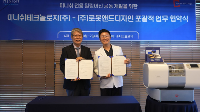 김진오 로봇앤드디자인 회장(왼쪽)과 강정호 미니쉬테크놀로지 대표가 업무협약서를 들어보이고 있다