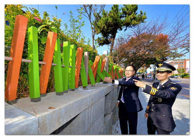 김종신 익산경찰서장과 정호석 하림 대표이사가 이리북일초등학교 담장에 나무 안전펜스를 설치하고 테스트를 하고 있다