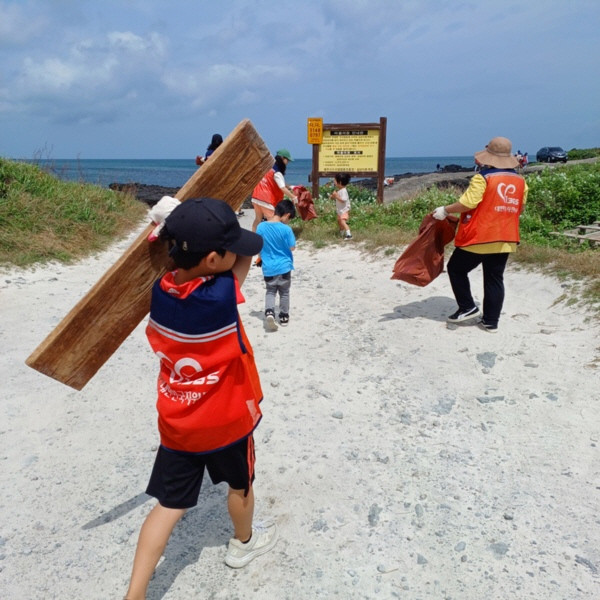 제주도에서 진행된 제1회 플로깅 행사에서 어린이가 바다에 버려진 쓰레기를 줍고있는 모습
