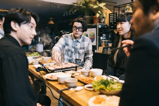 한국과 일본 국적의 친구들이 한국 스타일의 BBQ를 같이 먹으며 담소를 나누는 모습