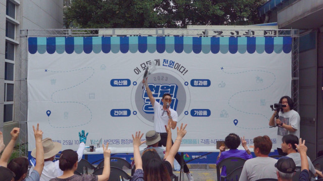 동두천시 생연동 원도심 상권진흥구역을 찾은 시민들이 ‘천원경매 이벤트’에 참여하고 있다