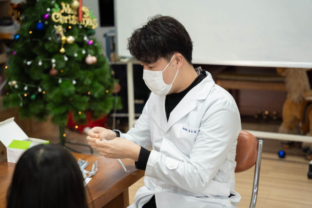 제이엘치과 김두희 대표원장이 이화영아원 아이들의 치아 진료를 하고 있다