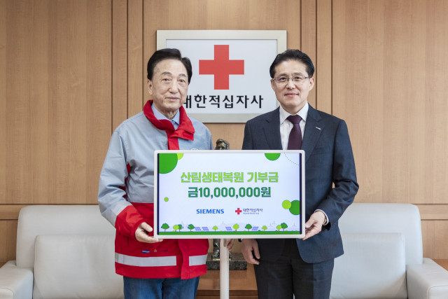 HaJoong Chung (right), President and CEO of Siemens Korea, and ChulSoo Kim (left), Chairman of Korean Red Cross, pose for a photo on April 1 at the Korean Red Cross Seoul office during a donation delivery ceremony for the creation of an ecological forest in the Civilian Control Line area