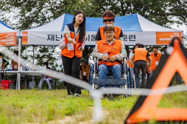 2024년 재난 현장 통합자원봉사지원단 모의훈련 재난 약자 이동 체험 중인 참가자들 모습