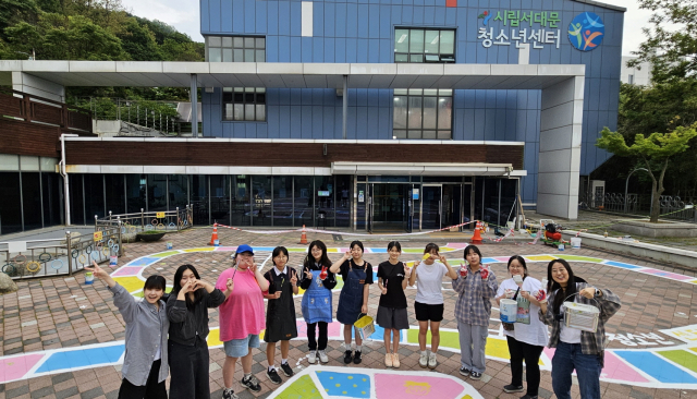 서대문청소년센터 청소년운영위원회 ‘꿀비’의 청소년 위원들이 센터 앞마당 바닥화 개선 작업을 완료한 후 기념사진을 촬영하고 있다